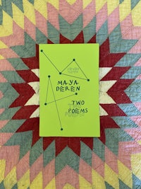 a book with a green cover sitting on top of a quilt